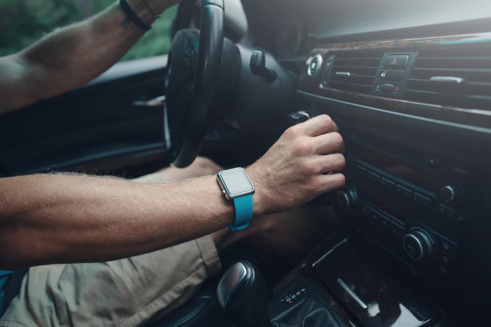 man-tuning-radio-car-smart-watch.jpg