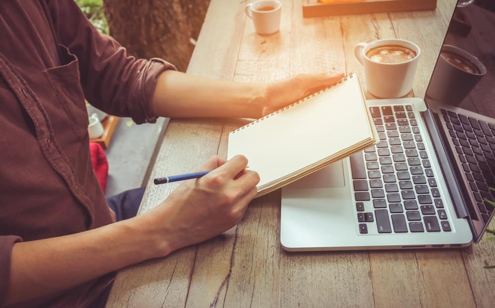 man-writing-notebook-laptop.jpg