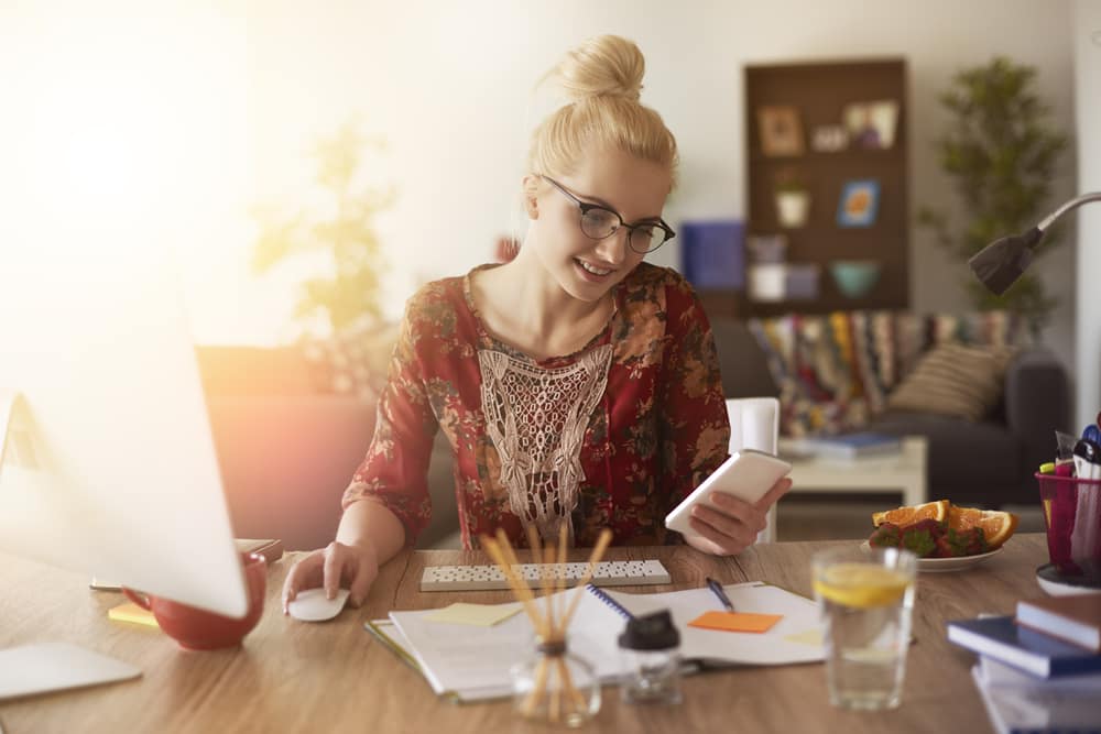 young-woman-home-office-checking-cell-phone.jpg